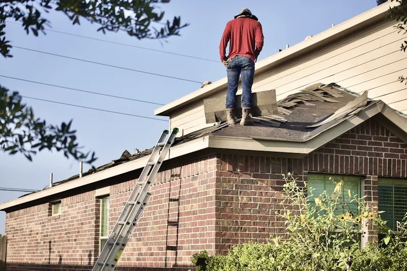 Professional roofer working on a residential roof in Genesee